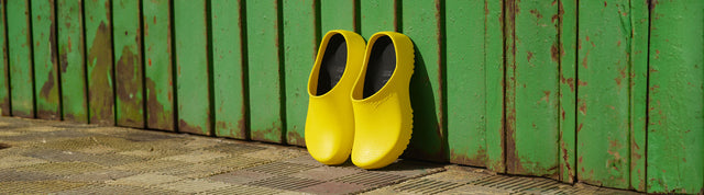 scarpe birkenstock professional super-birki unisex gialle appoggiate su sfondo verde