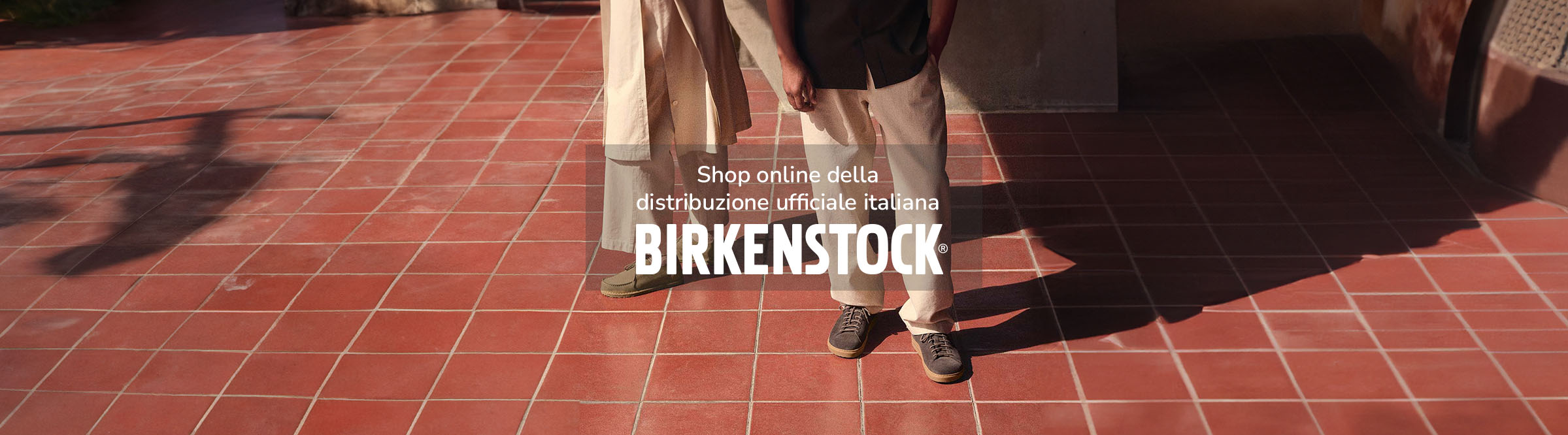 Mezzo busto inferiore di donna che indossa Arizona Big Buckle Sandali Donna tabacco brown con jean marroni e giacca di pelle lunga