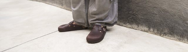 dettaglio uomo che indossa ciabatte a punta chiusa birkenstock boston sabot marroni