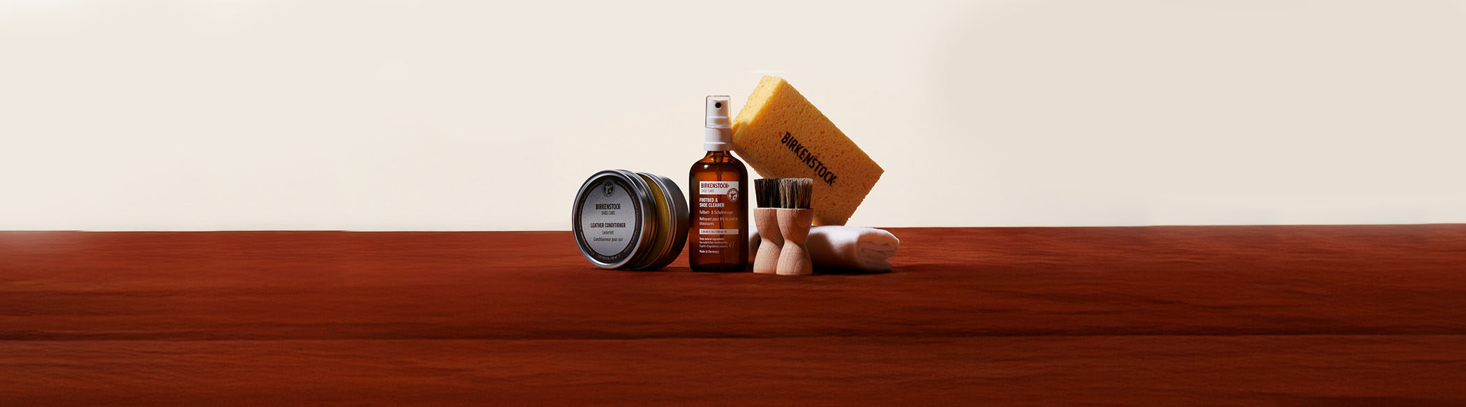 Kit completo per la pulizia e la cura delle calzature Birkenstock: Leather Conditioner, Footbed & Shoe Cleaner, spazzole in legno, spugna gialla e panno in cotone. Gli accessori originali Birkenstock garantiscono lunga durata e manutenzione ottimale di sandali, ciabatte e scarpe in pelle, con risultati professionali direttamente a casa.