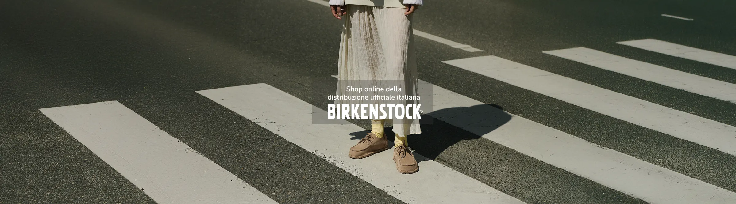 Metà busto di donna in strada con indosso birkenstock mocassini scarpe utti grey taupe