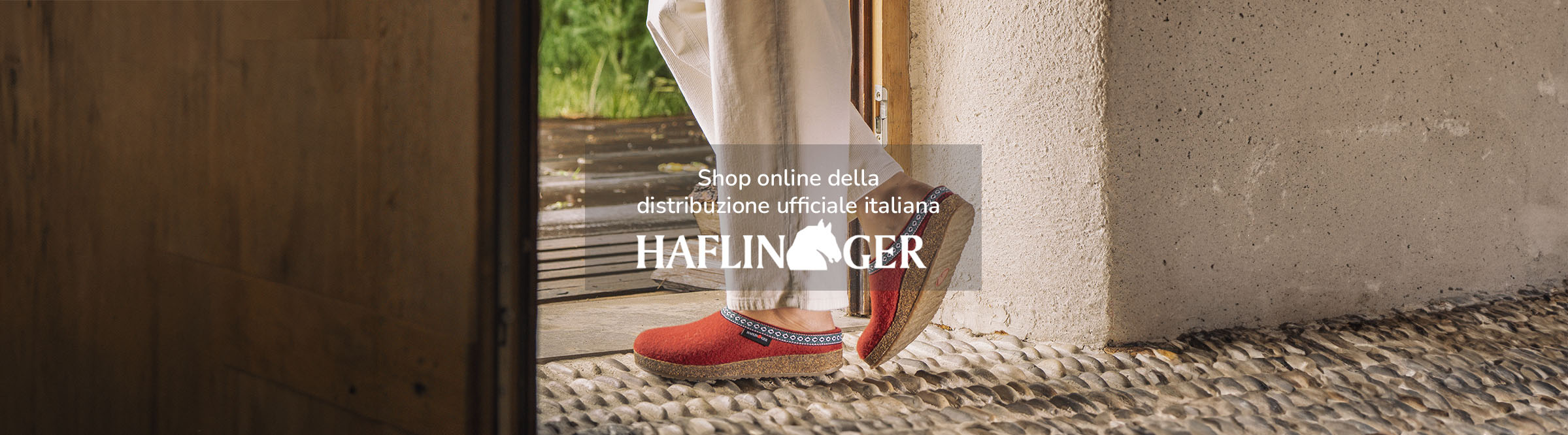 Primo piano di Haflinger sabot Franzl rosse indossate da donna con pantaloni bianchi