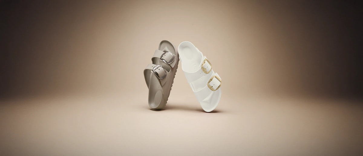 vista frontale di ciabatte impermeabili birkenstock con big buckle color bianco e beige su sfondo neutro beige
