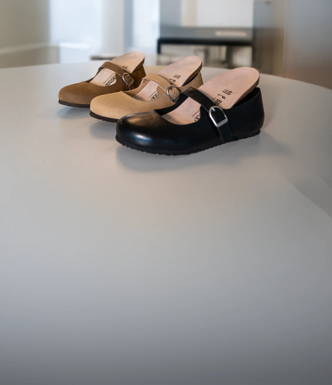 ballerine birkenstock scarpe santa clarita in tre colorazioni: marrone, beige e nera con plantare estraibile appoggiate su un tavolo bianco 