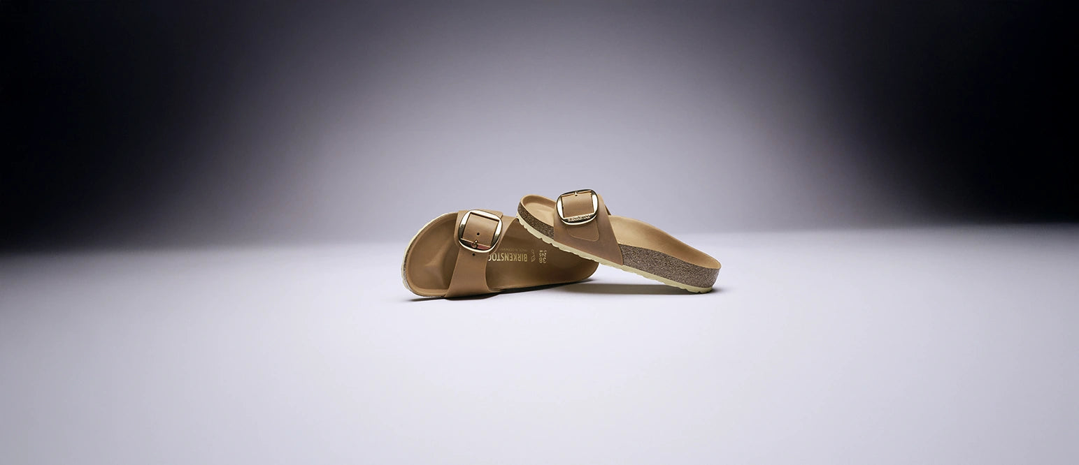 primo piano su sfondo viola di sandalo ciabatta birkenstock madrid big buckle cognac con vista frontale e laterale del paio