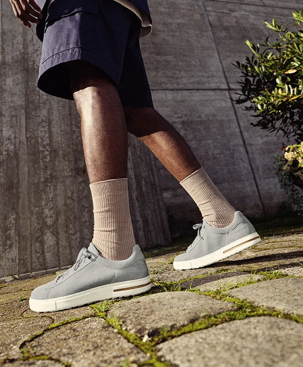 Primo piano di bend low scarpe birkenstock stone coin indossate da uomo che cammina