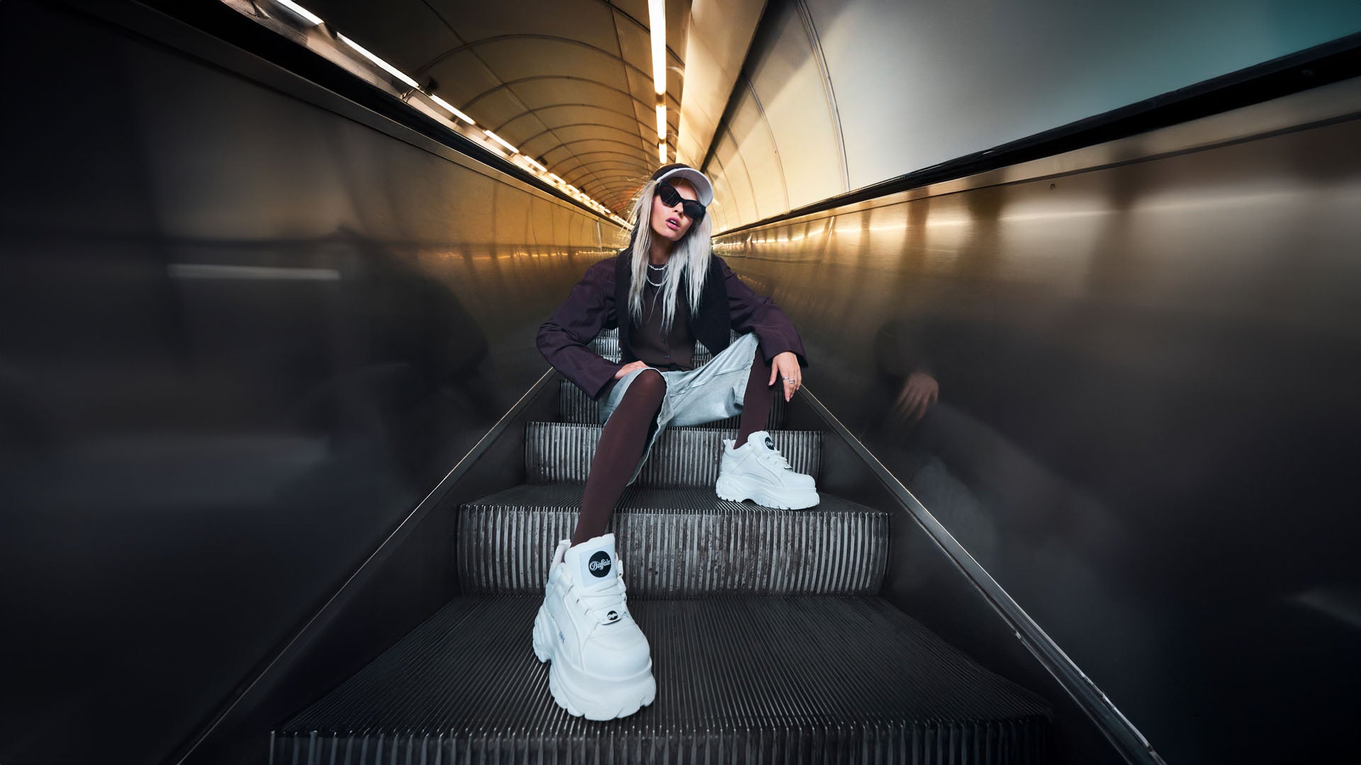 Ragazza seduta su scale mobili con indosso 1339-14 2.0 Scarpe Donna white di buffalo