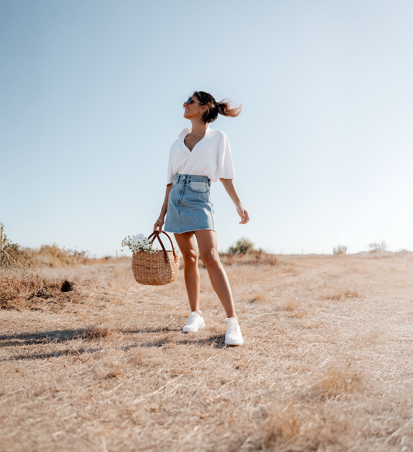 Donna con sneakers bianche EMU Australia in un contesto naturale, perfette per il tempo libero