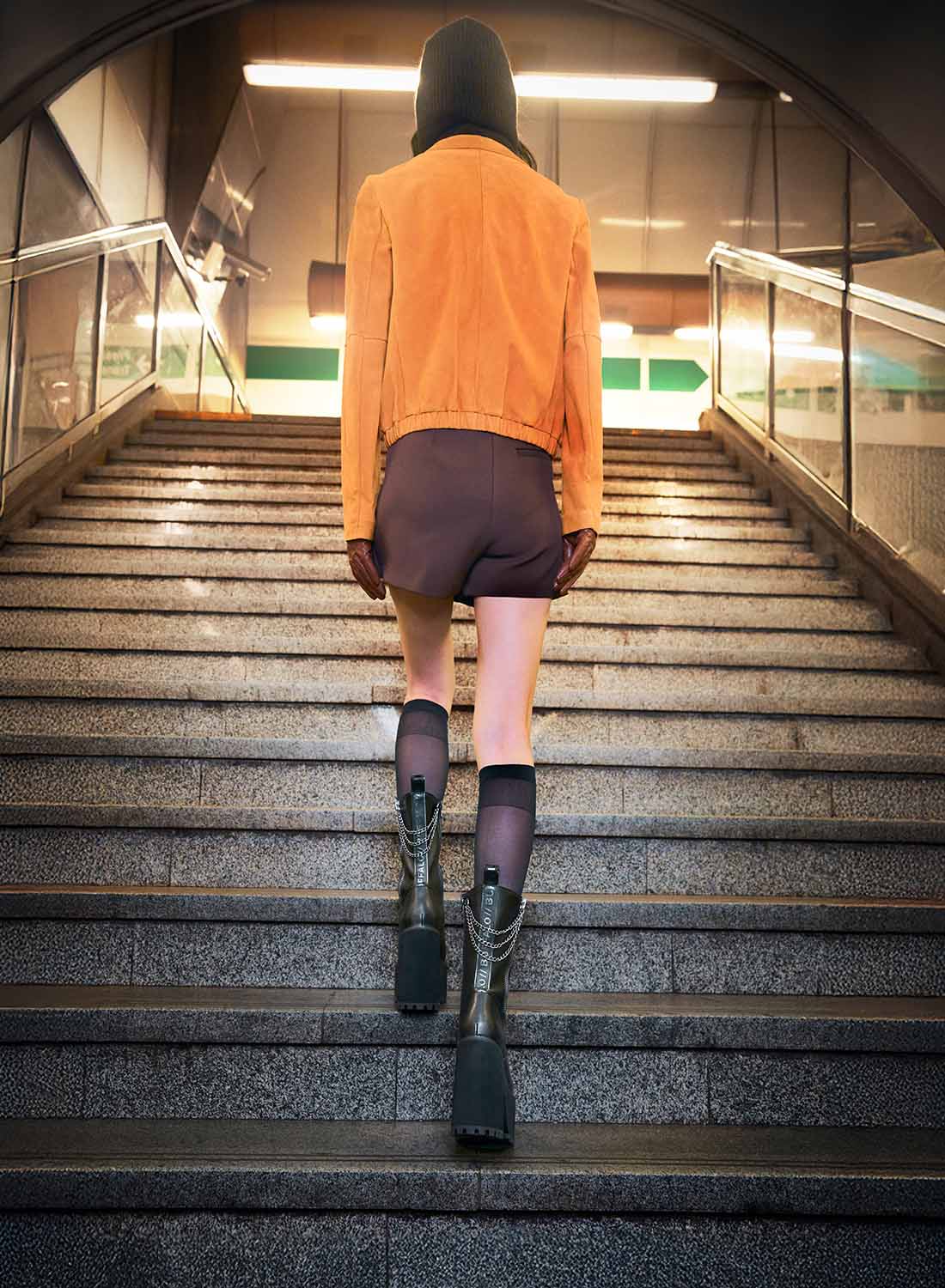 Ragazza sale scale con indosso stivali Buffalo neri