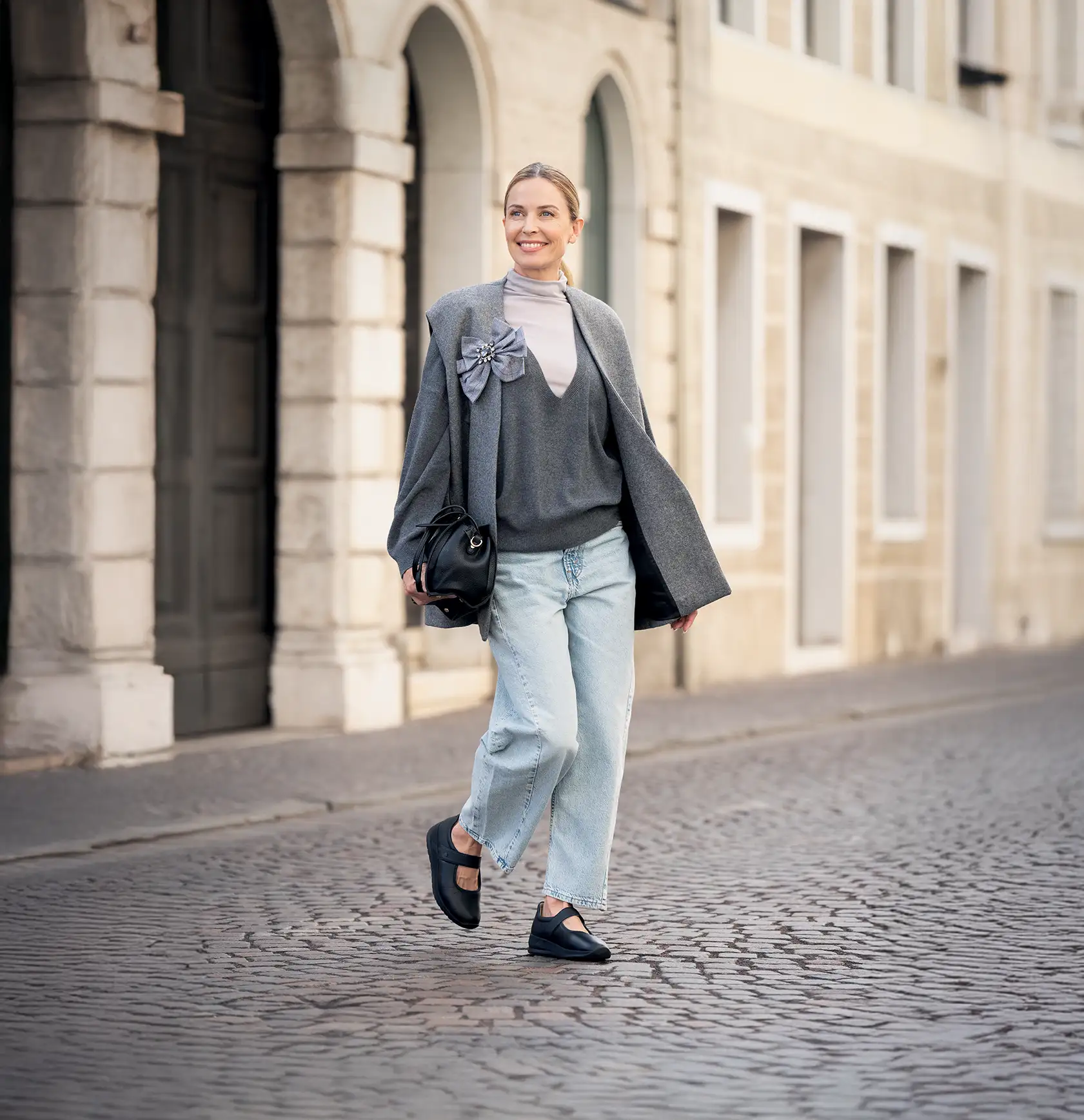 donna cammina per strada con indosso scarpe ballerine finncomfort nere sakai