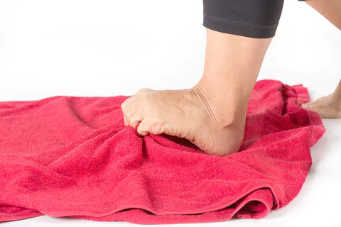 Esercizio piedi: afferrare con le dita un asciugamano