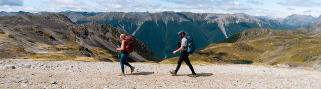 donna e uomo che camminano in montagna indossando keen targhee