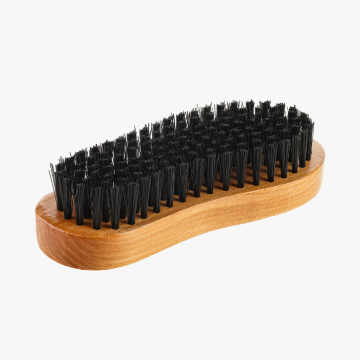 Primo piano di una spazzola con setole nere in nylon e manico in legno naturale, su sfondo bianco.